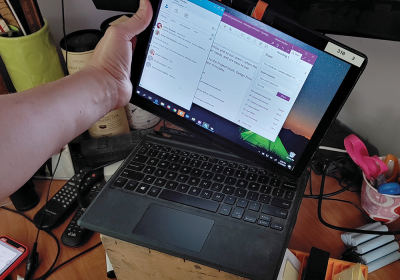 A picture of a person removing the tablet portion of a detachable Windows PC