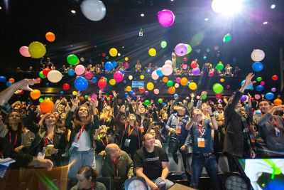 An audience throwing colored balloons into the air, taken from the stage