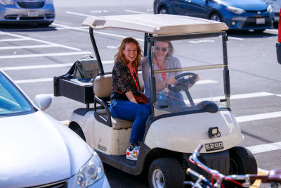 A picture of Charis Rhooda and Ari Stiles sitting in a golf cart