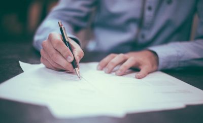 man holding pen on paper