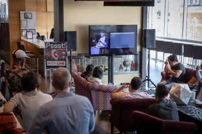 People on sofas watching a presentation via a live stream