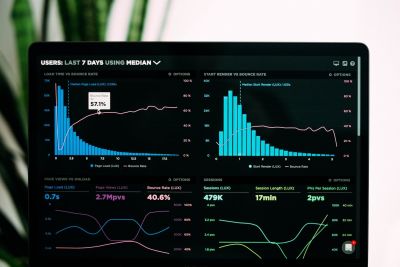 A photo of a laptop screen displaying 4 charts showing line and bar graphs comparing different user metrics