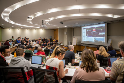 Auditorium style lecture room with people working on laptops