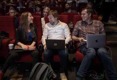 A photograph of three speakers sitting with the audience and chatting at SmashingConf Toronto