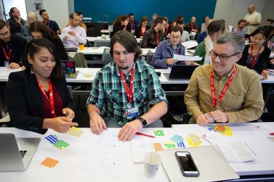 People behind desks working with stickers and paper