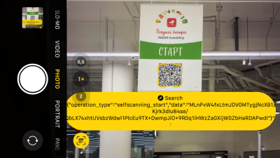 An advertisment in a mall showing a QR code that needs to be scanned with a phone camera