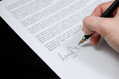 Hand writing signature on a piece of paper