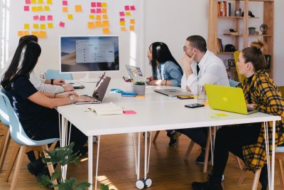 Team of people around a desk looking at a monitor