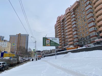 A billboard advertisement with tiny ad text and a QR code that are impossible to access from the street