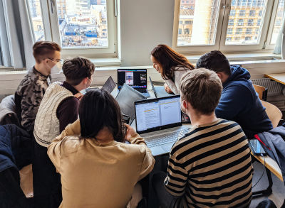 A classroom with students sitting in a circle next to each other with opened laptops during an accessibility workshop