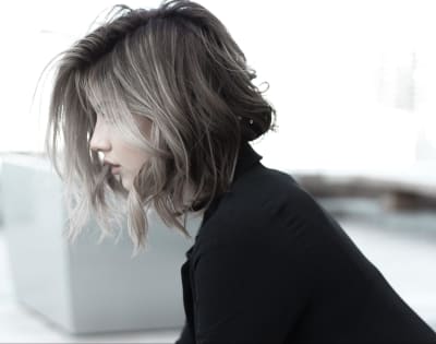 An image of a woman with her face covered by her hair so that her facial features cannot be seen well
