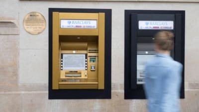 Image of a man standing at a cashpoint