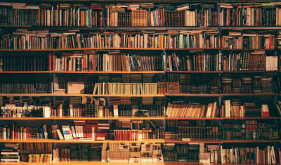 A bookshelf containing hundreds of books stacked in various directions, and organized in a way that is most likely unintuitive to an outside observer