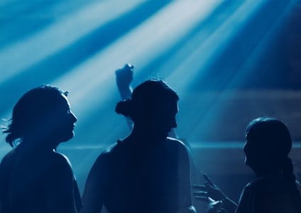 The Night Owl — silhouettes dancing under club lights