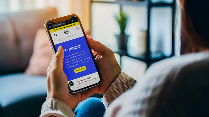 Girl using phone to book a unique experience on the Indytute website