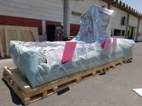 Infinity Pack & Ship specialists performing a precision rigging operation for sensitive equipment inside a high-tech clean room environment.