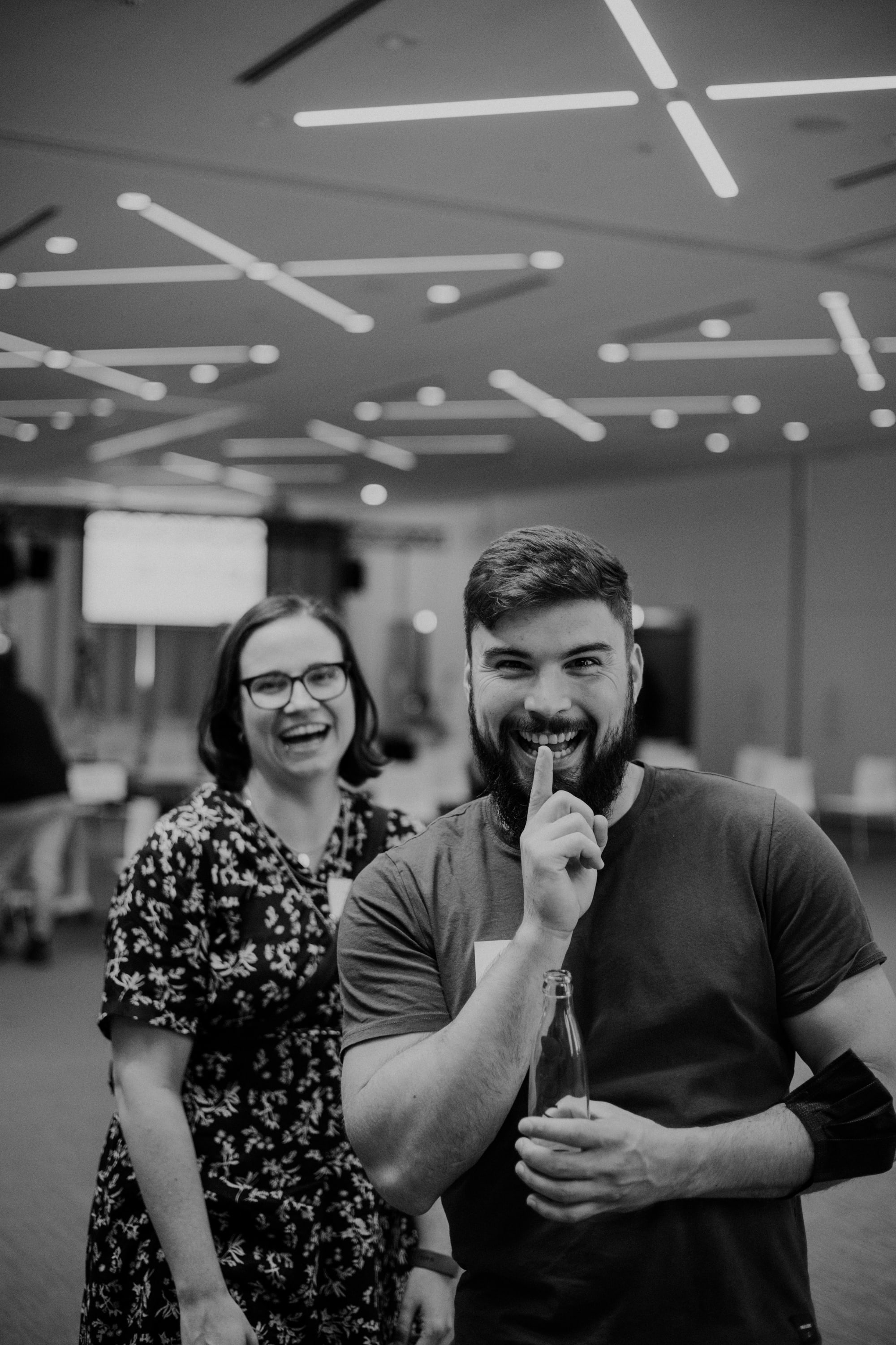 Eine Kollegin und ein Kollege lachen in die Kamera. Das Foto entstand auf einem INNOQ Event.