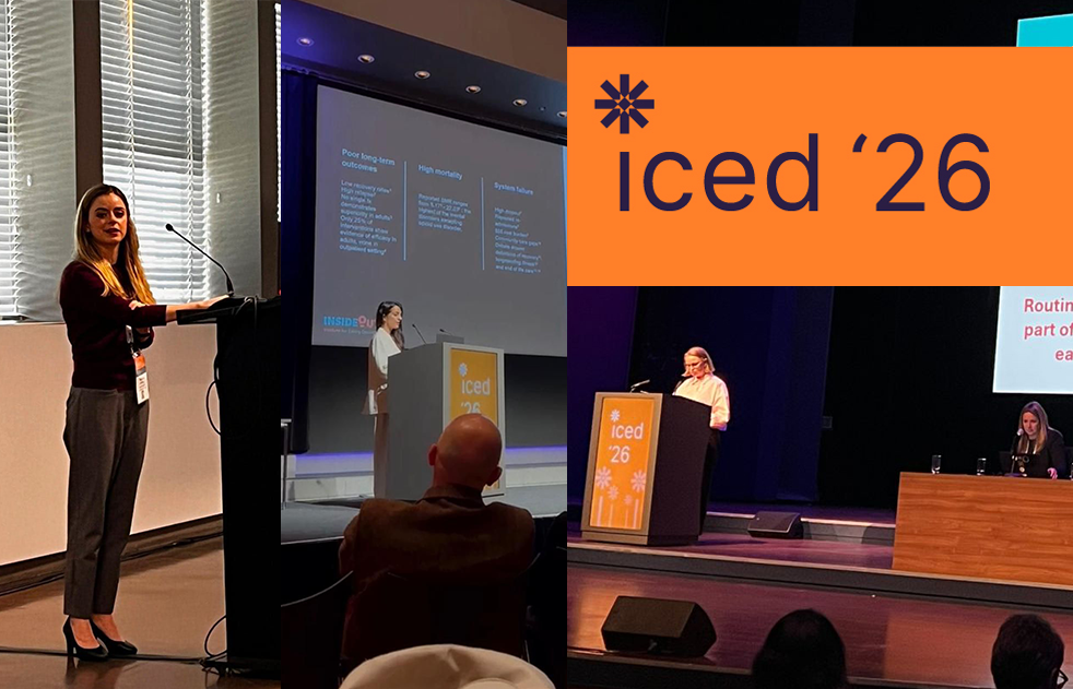 In the foreground, a woman presents at a podium on a stage with an audience seated in the background, while a large orange logo with "iced '26" is visible on the left.