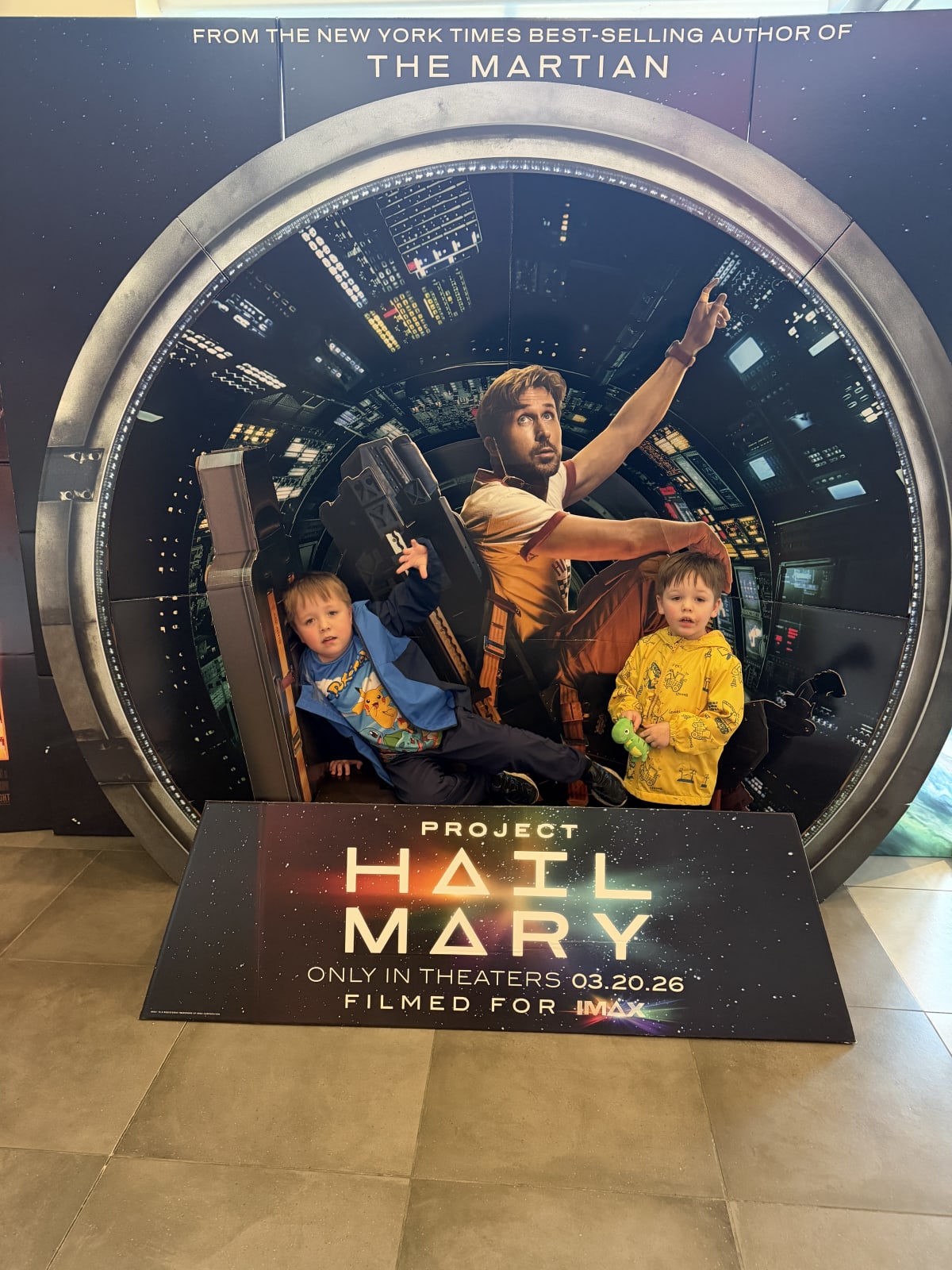 Ryan and Owen in front of a cardboard standee of Project Hail Mary.