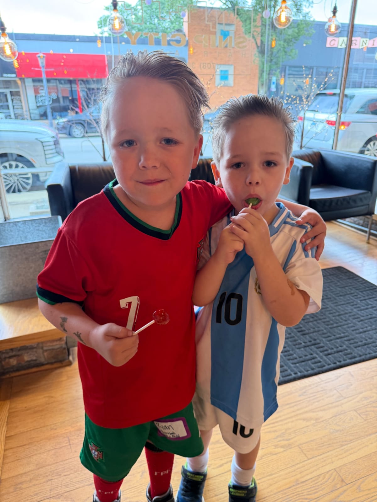 Ryan with his arm around Owen, both with fresh haircuts, slicked back and cropped short on the sides.