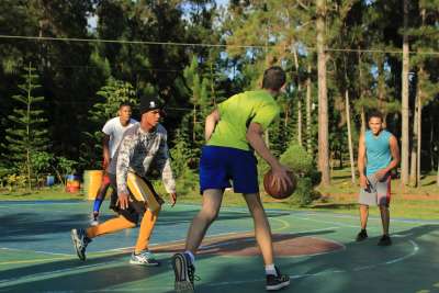 Estudiantes jugando baloncesto en la hora de deporte.