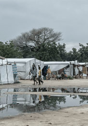 A displacement camp with white tents along a pathway.