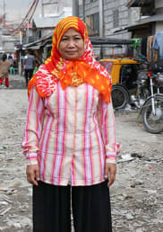 A woman stands in the slums in the Philippines.