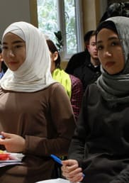 A group of women and men listen at a meeting in Kyrgyzstan
