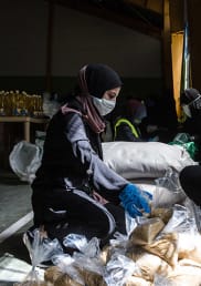 People pack food boxes for Lebanese families, who were already struggling with a financial crisis before the onset of the COVID-19 pandemic