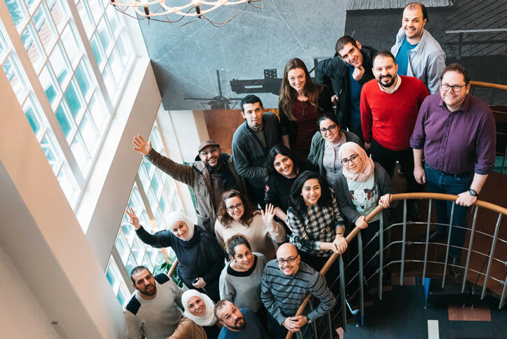 Aswat Faeela group standing in the stairwell following a meeting