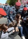 Young women blocking the streets, surrounded by police or soldiers.