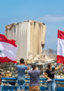 Lebanese wave the Lebanese flag at the scene of massive blast in Beirut