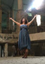 Monà Hallab stands inside inside the abandoned Opera House in downtown Beirut, smiling with her arms stretched out