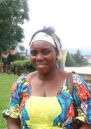 Borauzima wearing a blue and yellow dress with a white headband, smiling at the camera