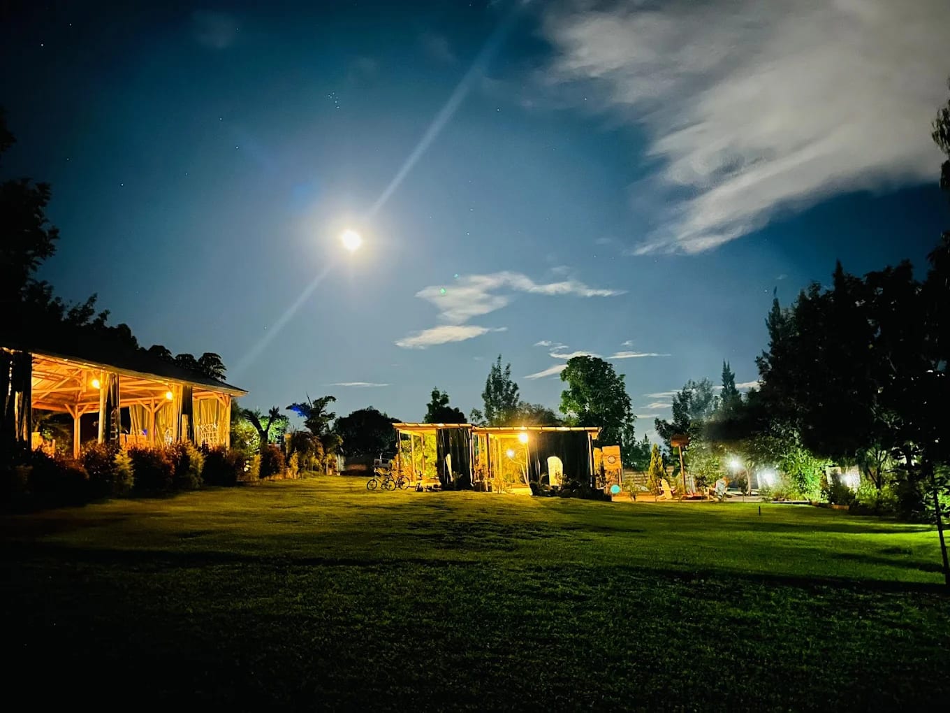 Resort grounds and lit buildings under a moonlit night sky