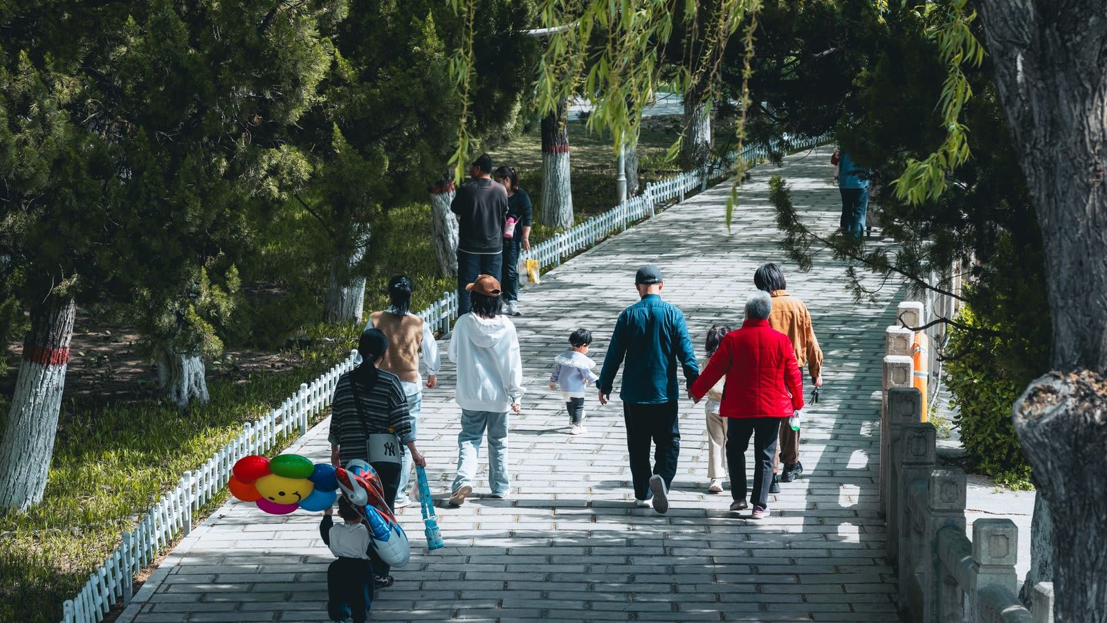 Pessoas de diferentes idades caminhando juntas em um parque.