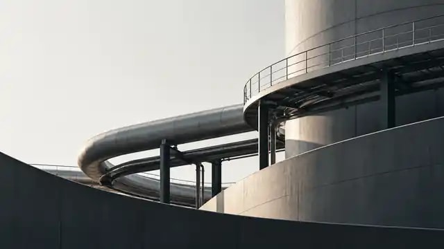 Layered industrial infrastructure with curved pipes and architectural structures