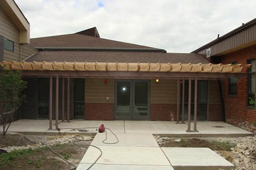 Exterior courtyard and pergola canopy between the original building and the new addition.
