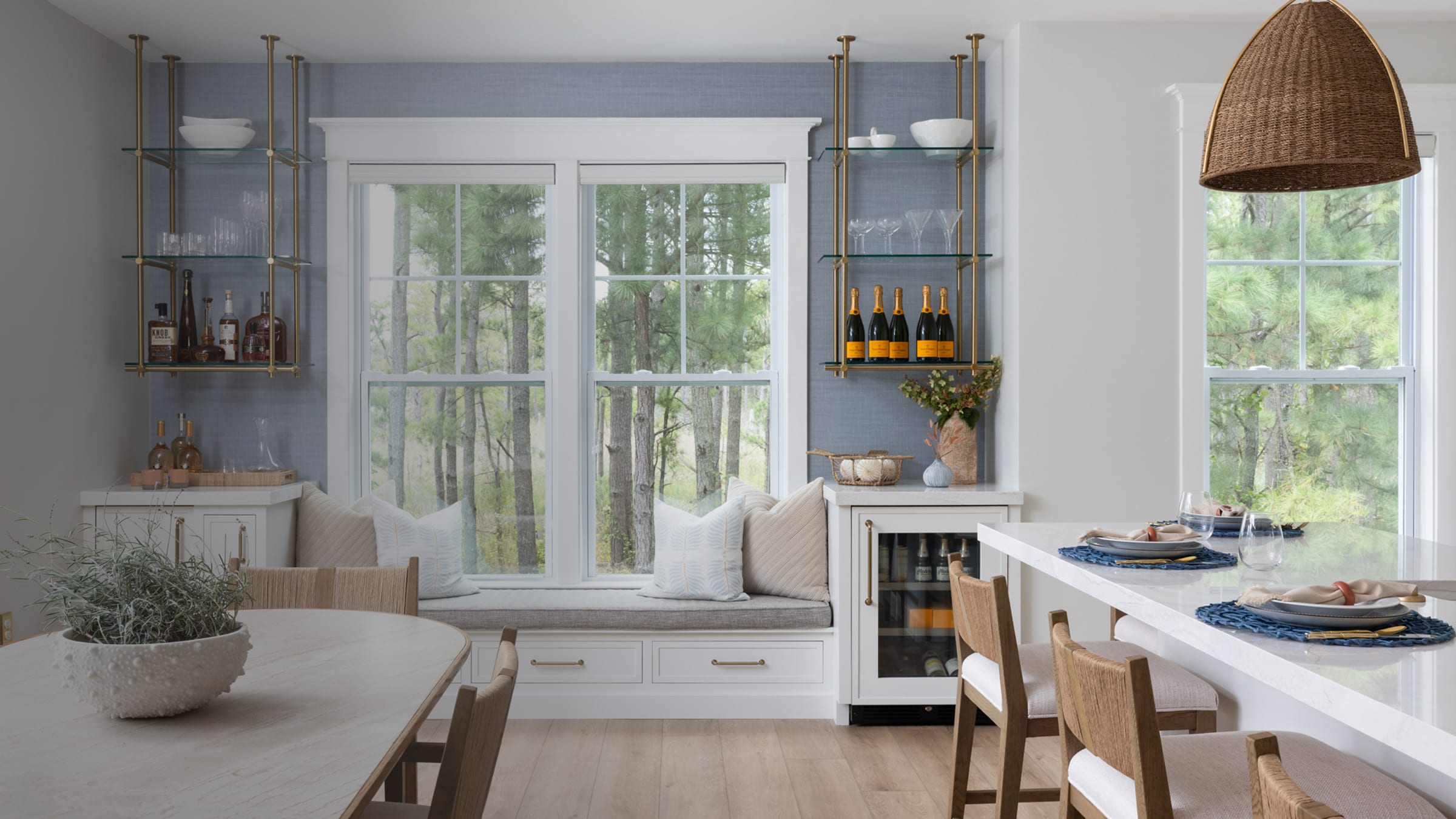 Brass ceiling-mounted glass shelving by Iron Abode in a home bar