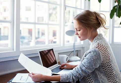 woman with a computer and work papers