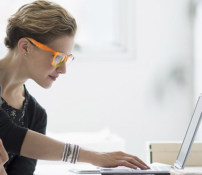 A man and a woman keep track of mutual funds on a laptop