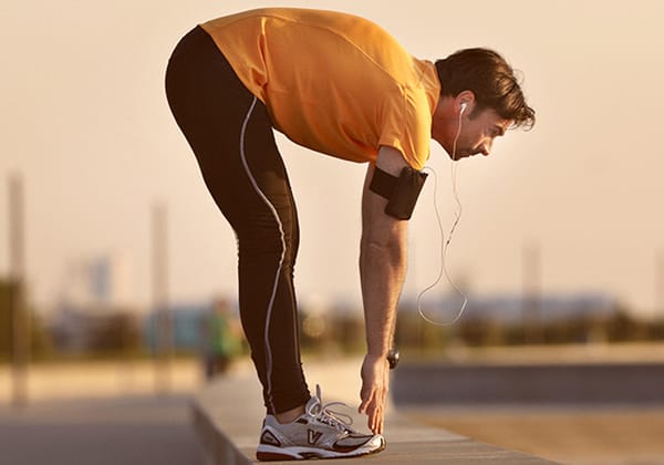 The runner on the pier is stretching. 