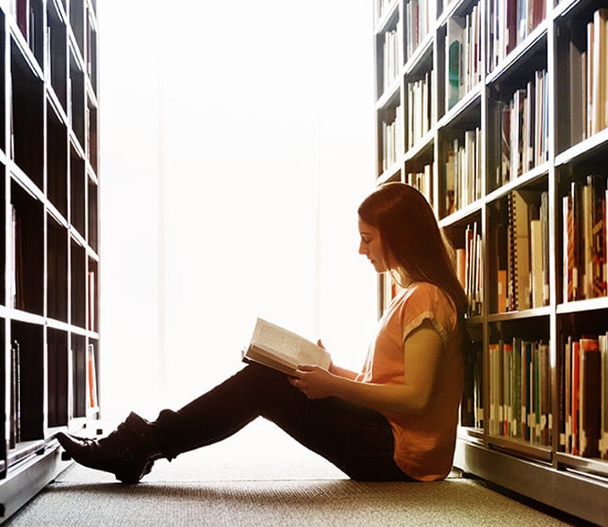Študentka med knjižnimi policami