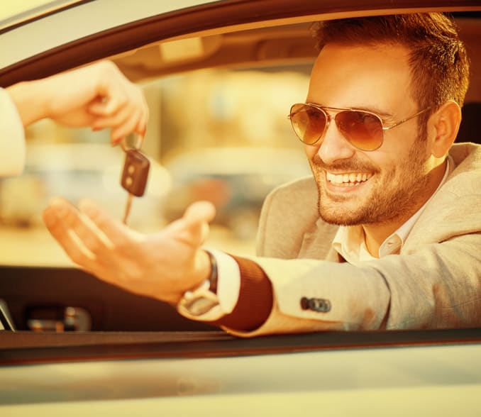Moški v vozilu sprejema ključe