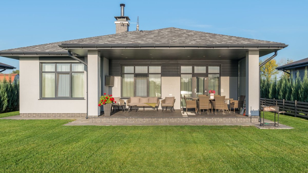 How to Design a Side Return Extension Contemporary house exterior with a large backyard patio and manicured lawn.