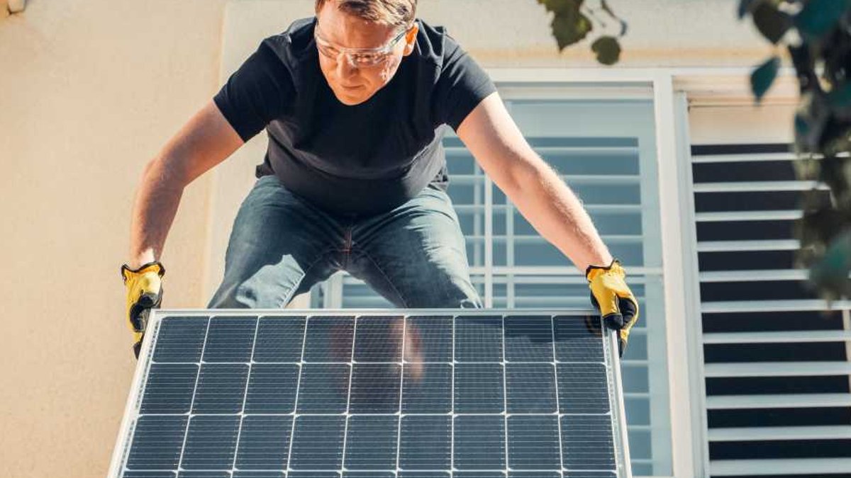 AI Subscriptions Are the New Electric Bill Man installing solar panel.