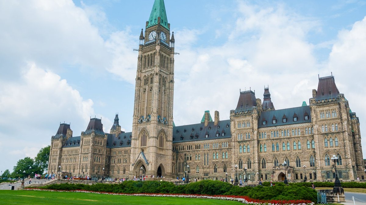 Stunning photo of Canada's Parliament Hill in Ottawa under a clear sky, showcasing Gothic Revival architecture.
