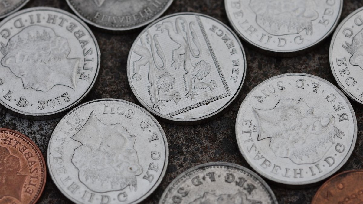 Most DB schemes now have a surplus Close-up image of various British coins on a textured stone surface.
