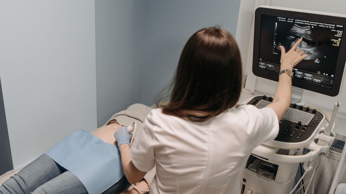 Female doctor conducting an ultrasound screening on a patient in a medical office.