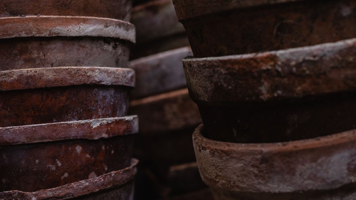 Detailed view of rustic earthenware pots stacked closely together, showcasing texture and craftsmanship.